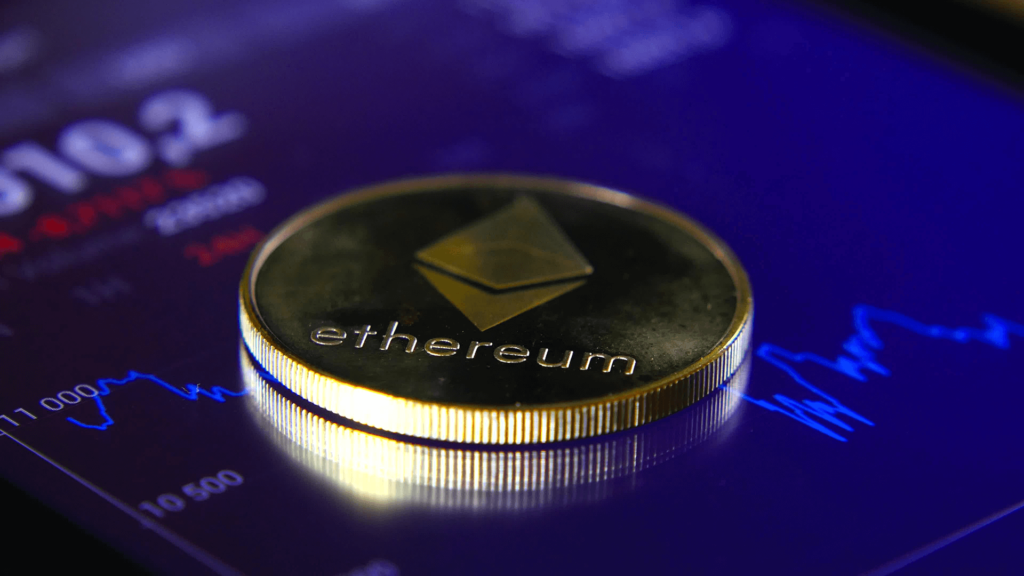 Gold Ethereum coin on top of screen with charts and numbers