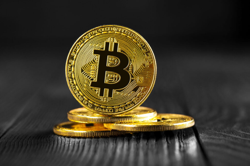 Gold bitcoins on black wood table