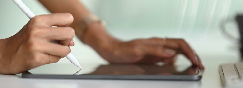 Woman holding pen signing on tablet